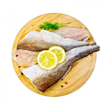 Fillet of cod on a round board with lemon and dill isolated on white background