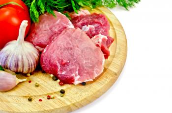Cuts of meat, garlic, tomato, parsley and dill on a round wooden board isolated on white background