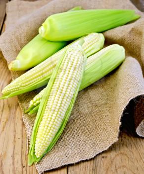 Corn on the cob on burlap on wooden board backgrounds
