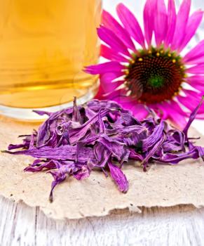 Echinacea dried on paper, fresh flowers echinacea, mug with herbal tea on a wooden boards background