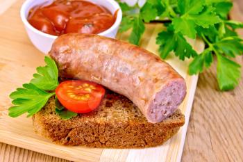 Fried pork sausage on a slice of bread with tomato, parsley, tomato sauce on a wooden boards background