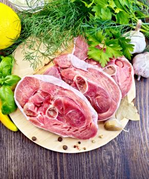 Steak meat raw turkey with pepper, basil, lemon and garlic on a background of wooden boards on top