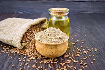 Flax flour in a bowl, seeds in a bag and on a table, linseed oil in a glass jar on a wooden board background