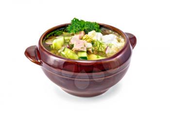 Cold soup okroshka from sausage, potatoes, eggs, radish, cucumber, greens and kvass drink in a clay bowl isolated on white background