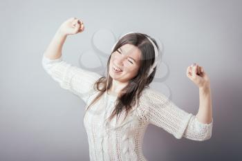 Young woman with headphones listening music .Music teenager girl dancing against isolated white background
