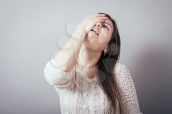 long-haired beautiful brunette girl made a mistake and holding his forehead