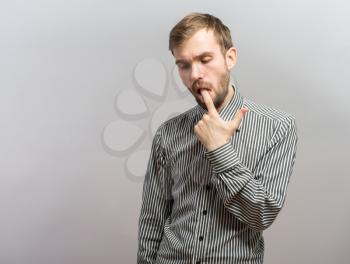 Closeup portrait young man with sensitive toothache bridge problem about to cry from oral pain touching outside mouth with hand. Negative emotion facial expression feeling