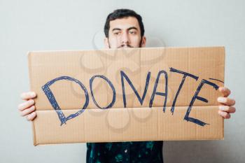 young man showing board with text: Donate