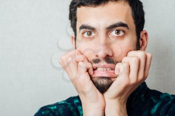 Office worker chewing on his fingernails with a worried expression
