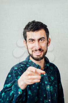 Casual young man pointing a finger towards camera and presenting with a marker 