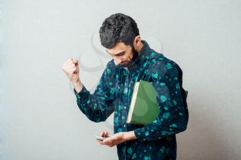 young casual man making the ok, victory, thumbs up hand sign while talking on the phone