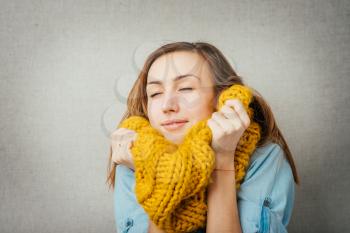 Woman basking cold scarf. isolated on gray background