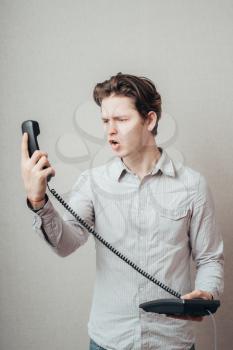 portrait of young man talking on a vintage telephone 