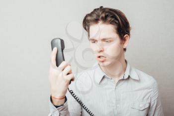 portrait of young man talking on a vintage telephone 