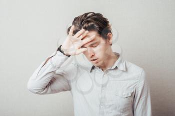 Handsome man with headache and the hand on forehead isolated on a white background