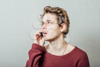 Man talking on the phone. On a gray background.