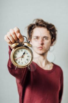 man holding an alarm clock in hands