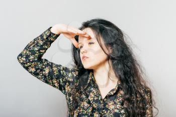 Woman with hand on forehead looking into distance