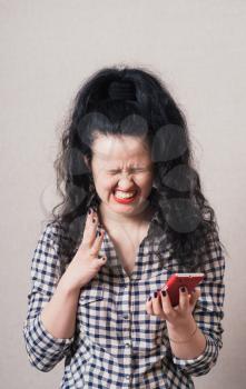 Woman reading a good sms message on the phone. Gray background
