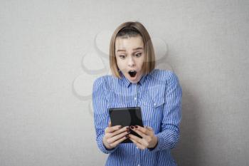 young woman with tablet in hand surprised