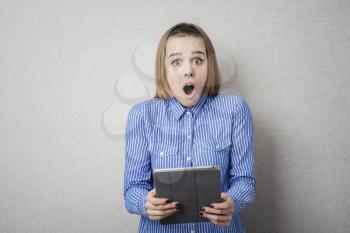 young woman with tablet in hand surprised
