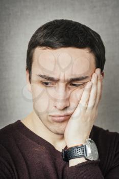 a young man upset with hand on face