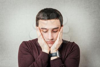 a young man upset with hands on face