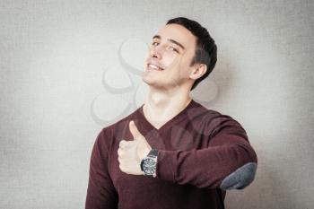 Portrait of a young man showing thumbs up