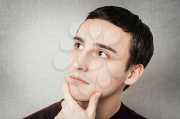 Young handsome thoughtful man thinking over something