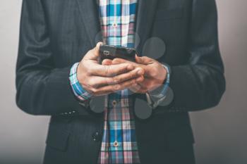 businessman holding a mobile phone in their hands