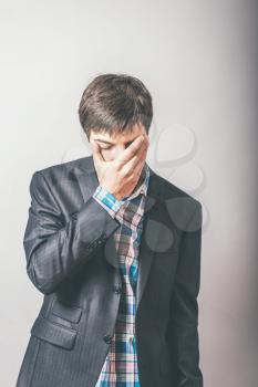 Businessman covers his face with grief