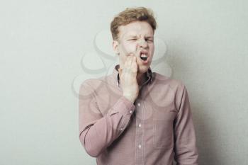 a young man feels toothache