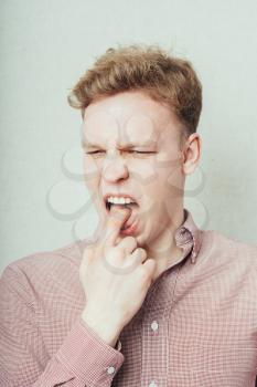 young man with finger in mouth