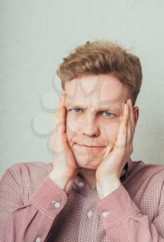 furious young men holding his head in hands