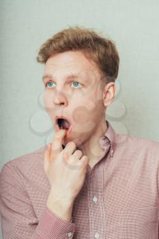 young man with finger in mouth