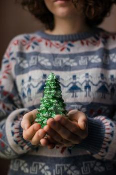 hands hold a christmas candle as fur-tree form