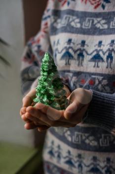 hands hold a christmas candle as fur-tree form