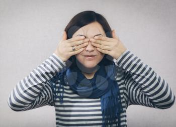 young woman covering her eyes with hands