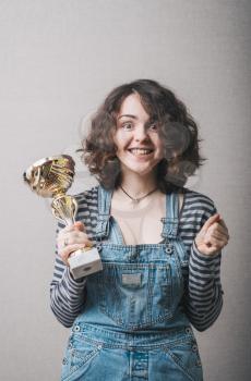 young girl holding a prize cup and happy