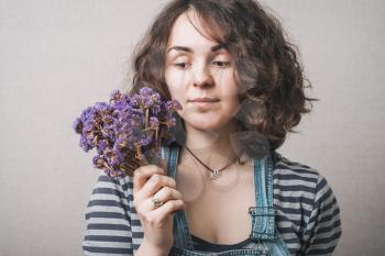 Woman with flowers . Gray background.