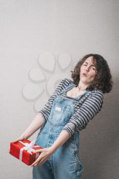 Woman hold gift. Isolated studio portrait. Smiling, happy girl.