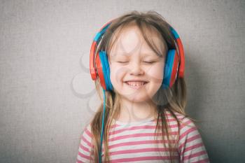 Beautiful cute happy little girl with headphones