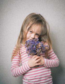 little girl with a bouquet of flowers in the studio