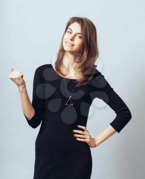 portrait of a cute brunette girl rejoices victory with clenched fists