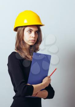 Beautiful young girl in the construction helmet