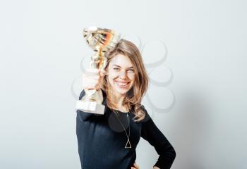 young girl holding a prize cup and happy