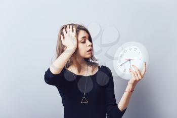 Shocked woman holding a clock