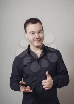Happy casual young man showing thumb up and smiling 