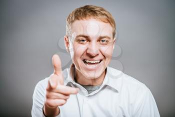 Portrait of a smiling man looking ahead and points a finger in a friendly gesture