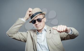 Happy man in hat and sun glasses giving thumbs up sign - full length portrait